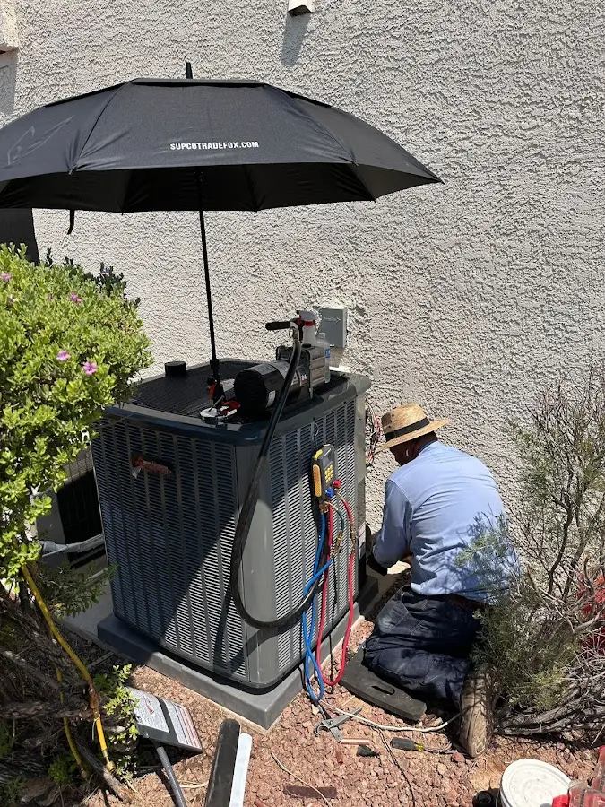 HVAC technician performing outdoor AC maintenance in Ledyard